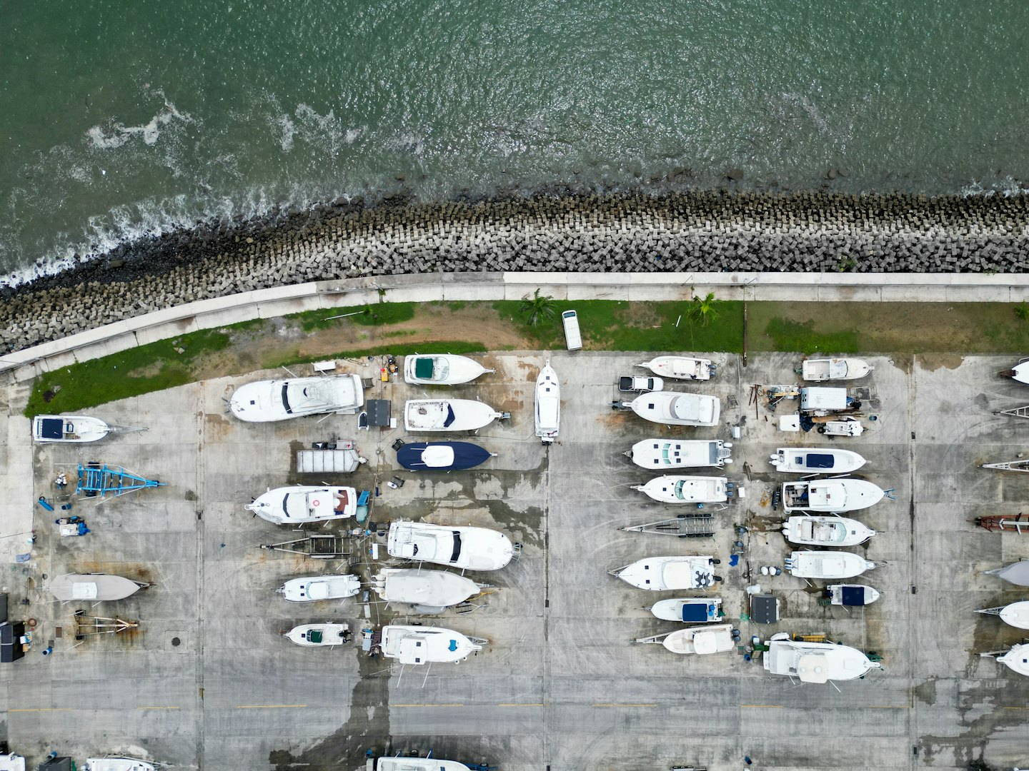 Barche ormeggiate in file in un cantiere navale marittimo vicino all'acqua.