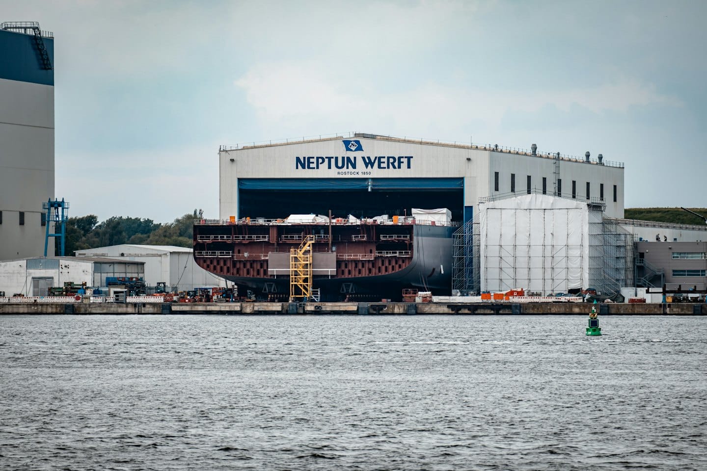 Una grande nave in costruzione in un cantiere navale asciutto.